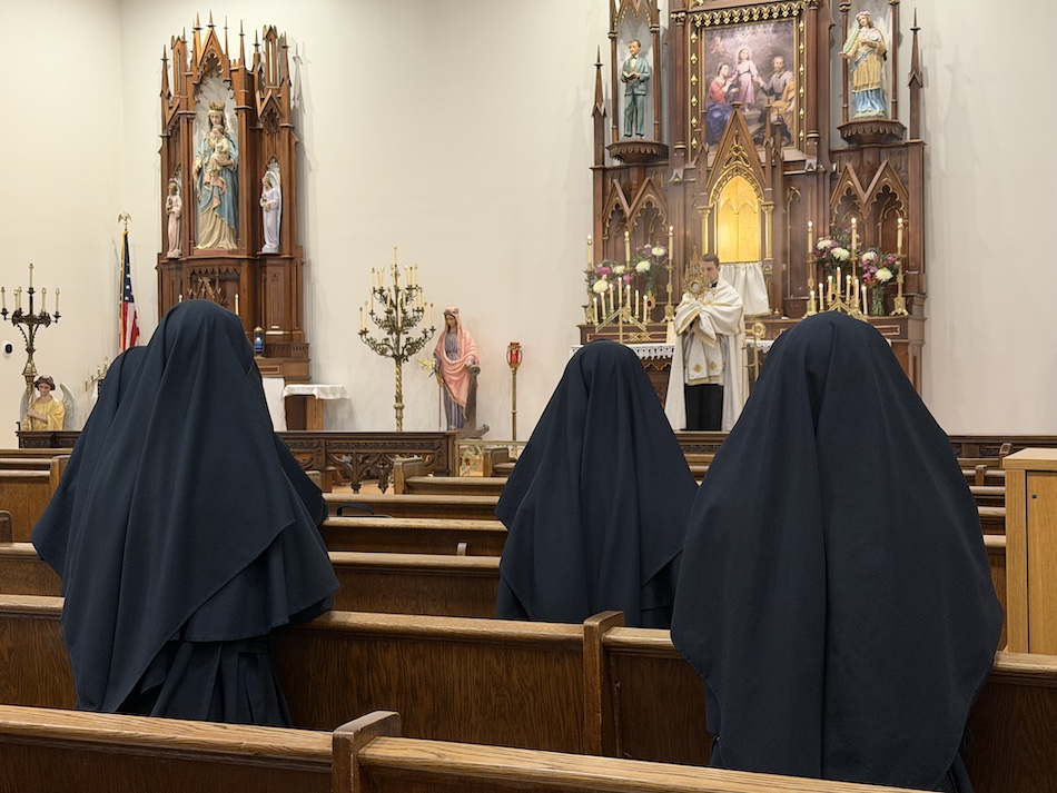 Sisters in prayer before the altar in chapel