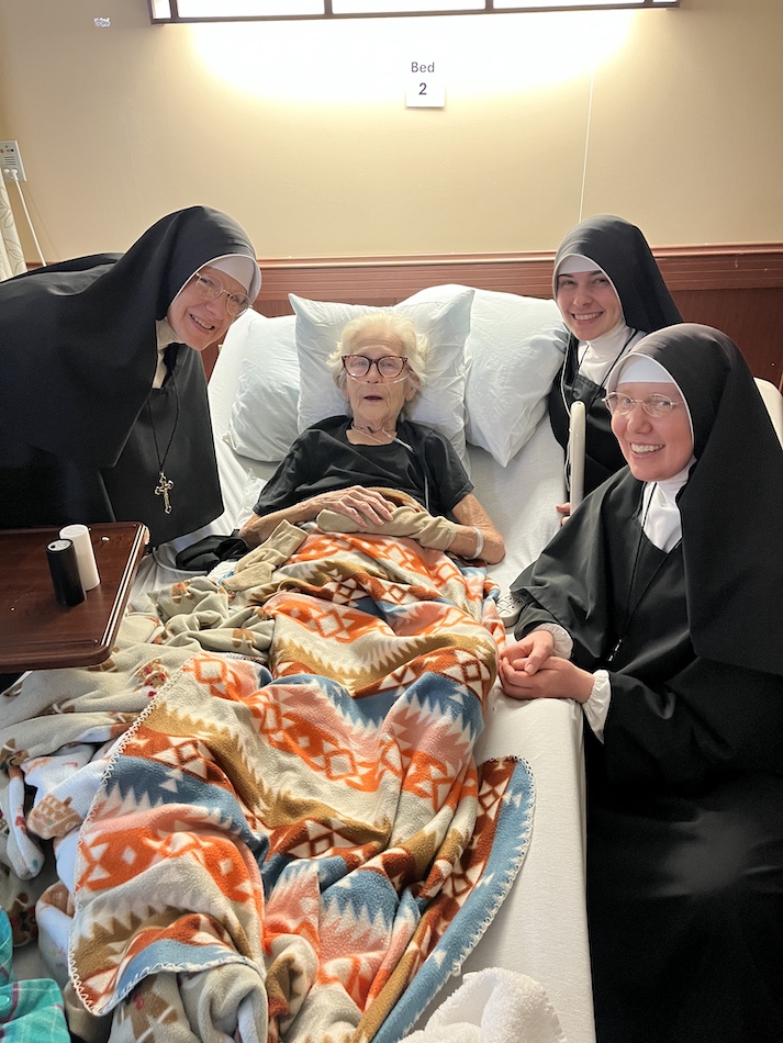 Sisters visit an elderly woman in the hospital