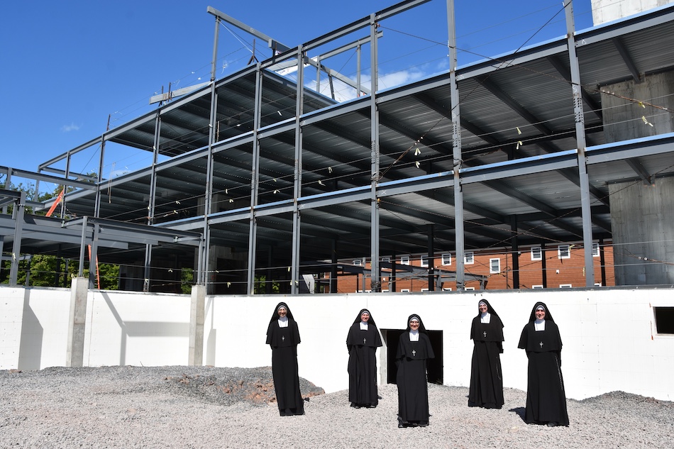 Sisters standing before the steel-framed building