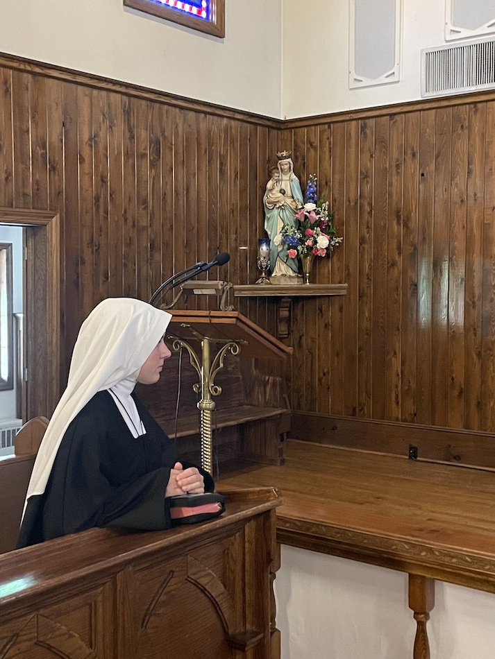 A Sister in quiet prayer in chapel